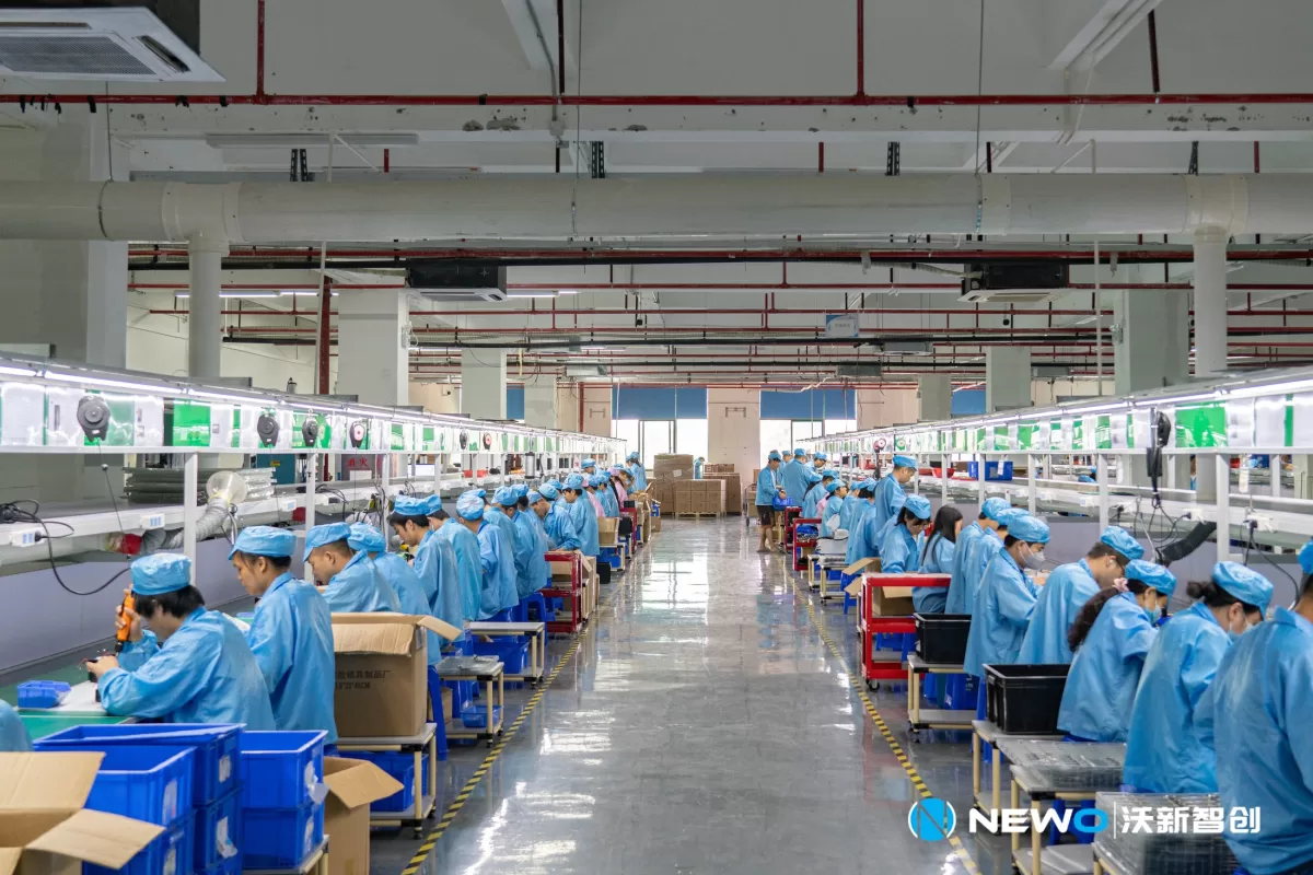 Wide view of the NEWO assembly line with team members at work