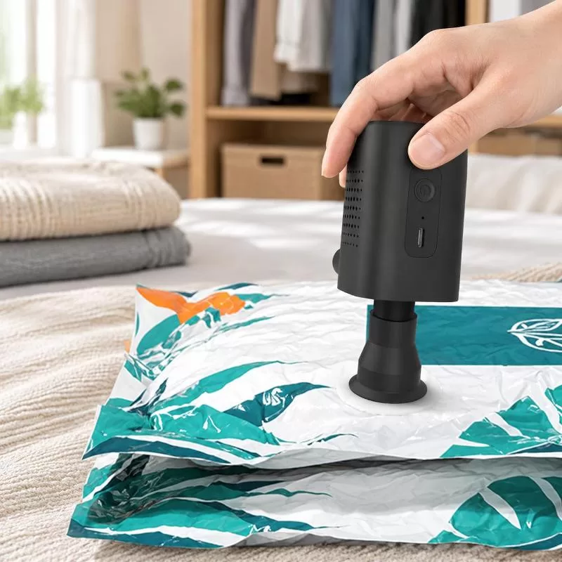 Hand holding the AP8-P while deflating a vacuum storage bag