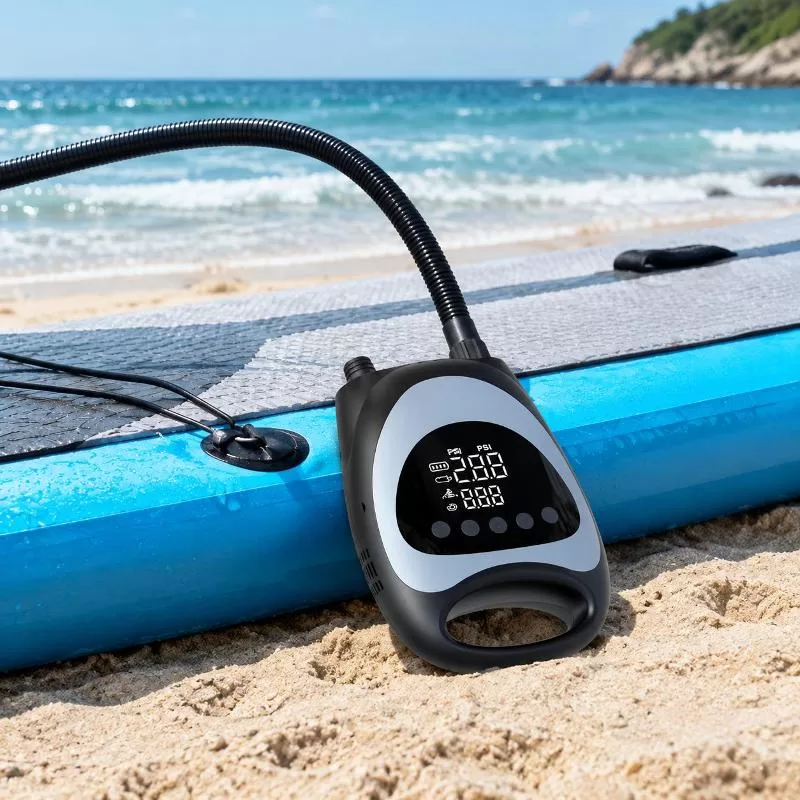 Angled overhead view of the electric SUP pump with hose, vehicle power cable, and inflation adapters arranged on a white background